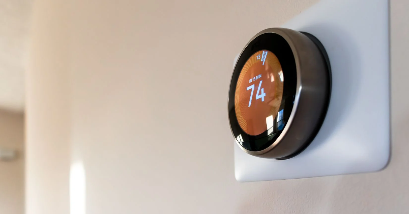 Digital wall thermostat displaying indoor temperature setting