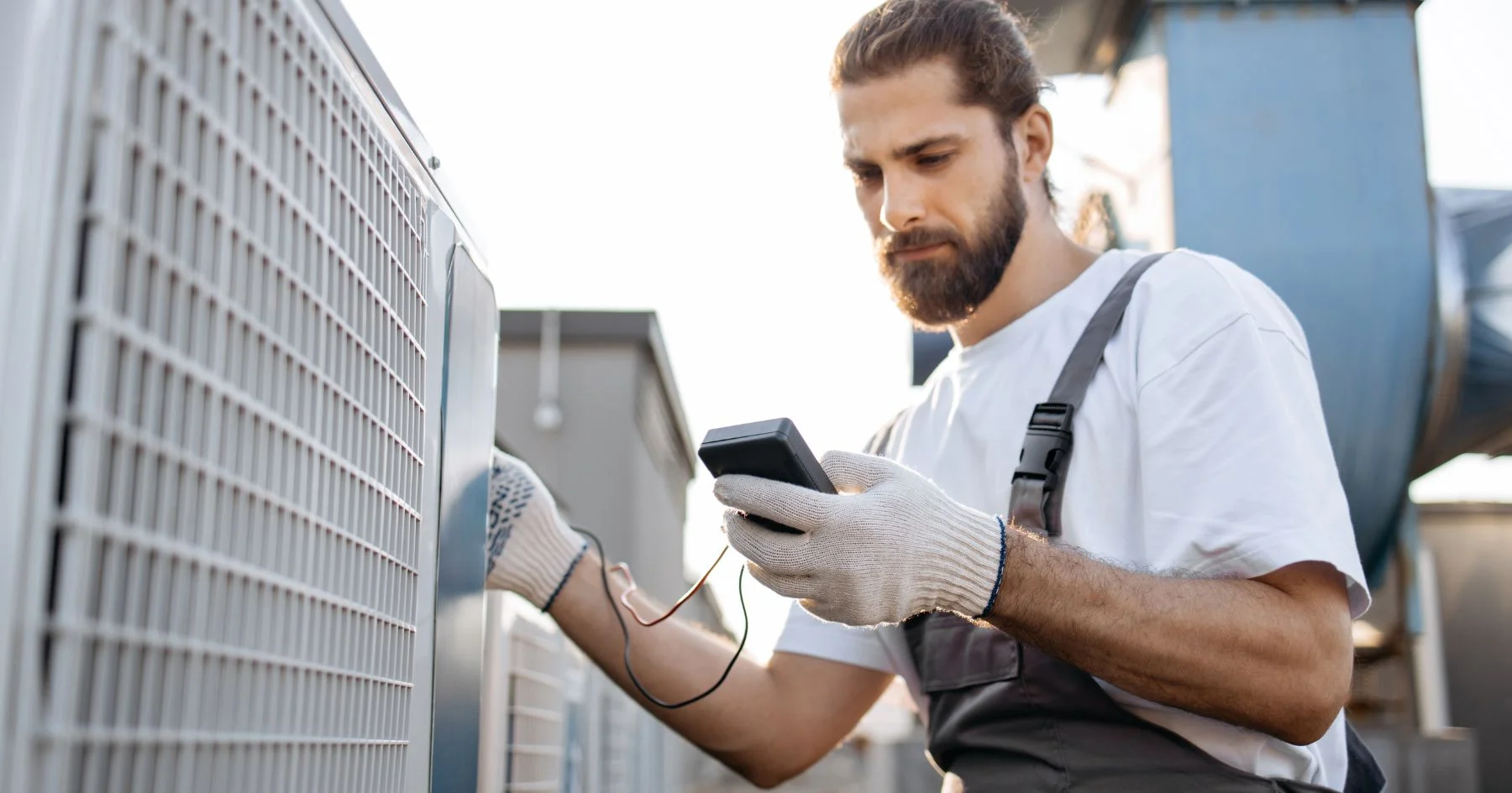 HVAC technician testing outdoor air conditioner unit